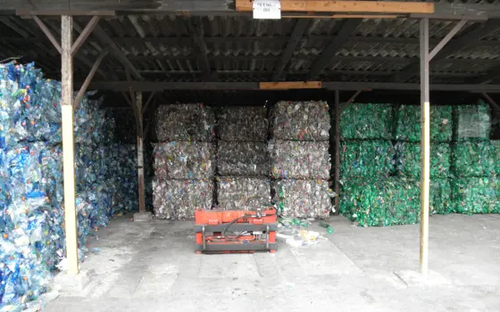 Cubed stacks of plastic waste under a shelter.