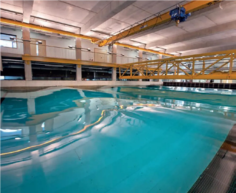 An indoor pool with waves being generated.