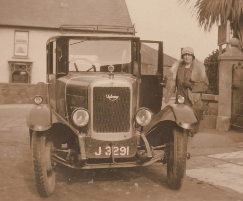 Dorothy Pullinger standing next to an old Galloway car.