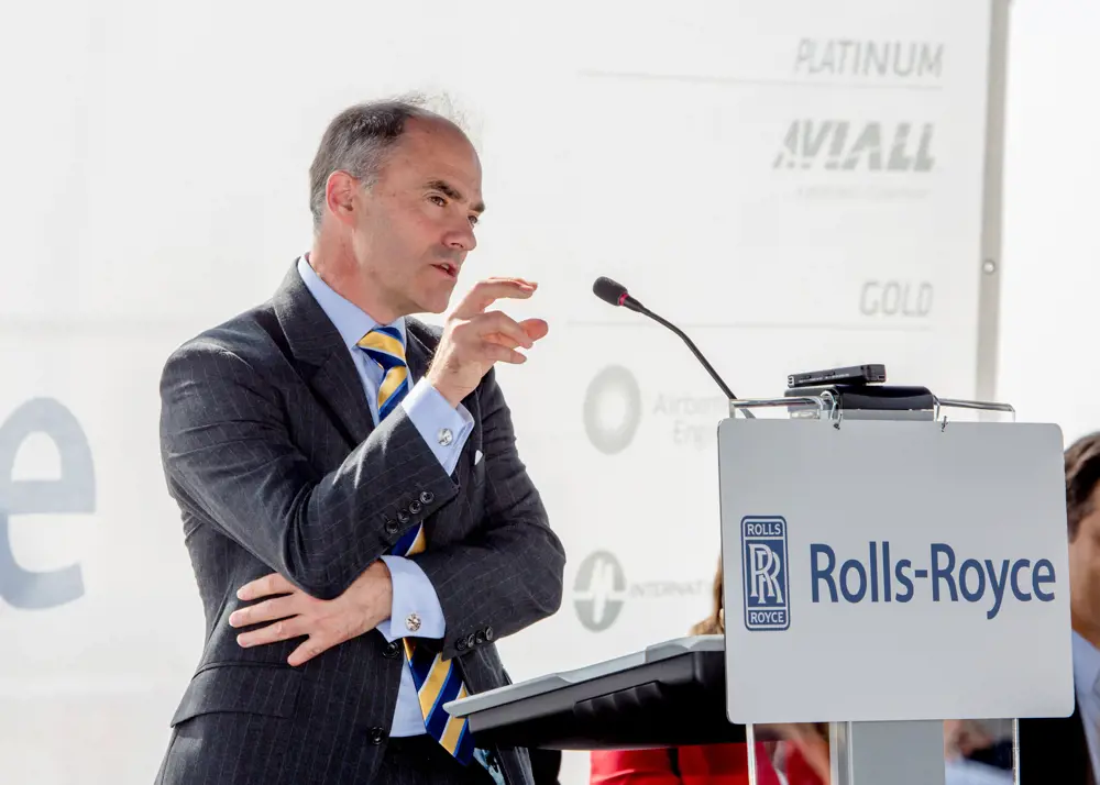 Warren East speaking at an event with the Rolls-Royce logo in front of the microphone.