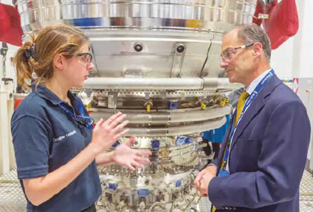 Warren East speaking to a female engineer inside Rolls-Royce's Derby manufacturing plant. 