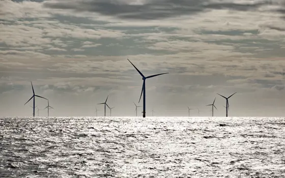 Wind turbines standing in the ocean.