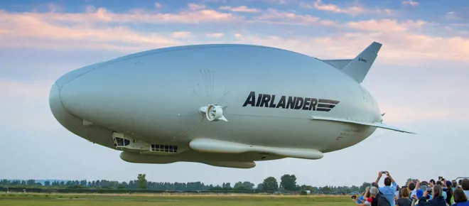 A crowd of people watching the Airlander coming into land.
