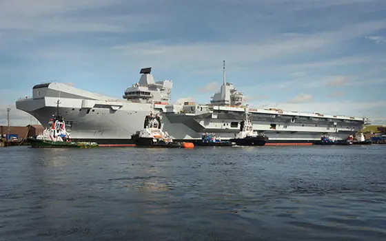 The HMS Queen Elizabeth parked at a dock. 