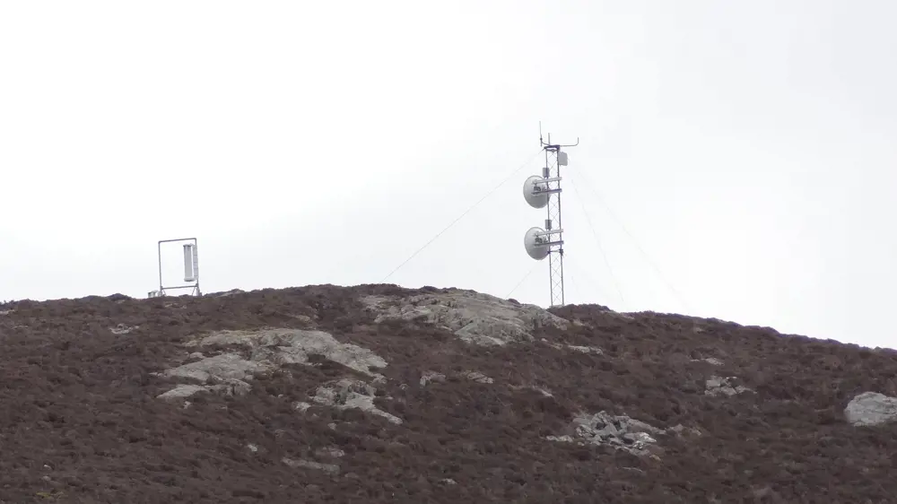 A tower with satellites on a hill in the Shetland Islands.