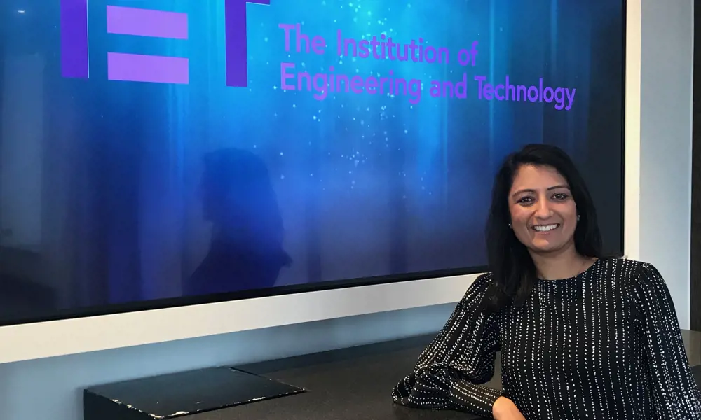 Mamta Singhal in front of a logo for the Institution of Engineering and Technology.