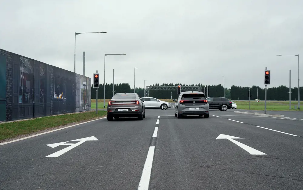 Two cars wait at the traffic lights, at a site simulating a city centre.