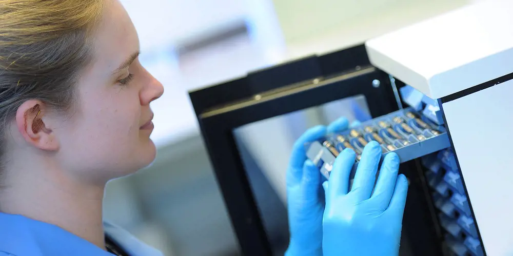 A scientist opening up a shelf on a container for the Breath Biopsy digital biobank.