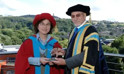 Professor Jiang and Sir Patrick Stewart in robes, holding a glass award.