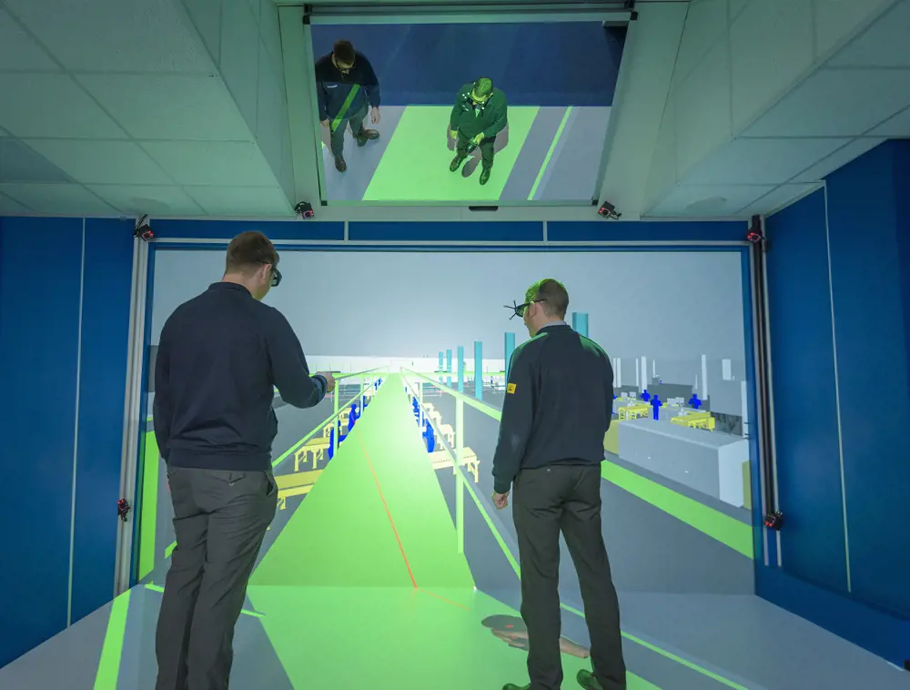 Two men wearing virtual reality headsets, simulating an assembly line.