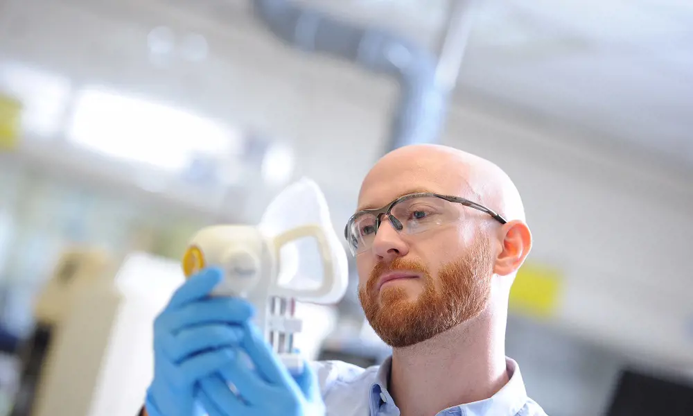 A person holding an Owlstone Medical device that captures breath samples.