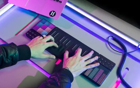 Two hands playing the ROLI instrument, stretched out across the silicon touchpad.