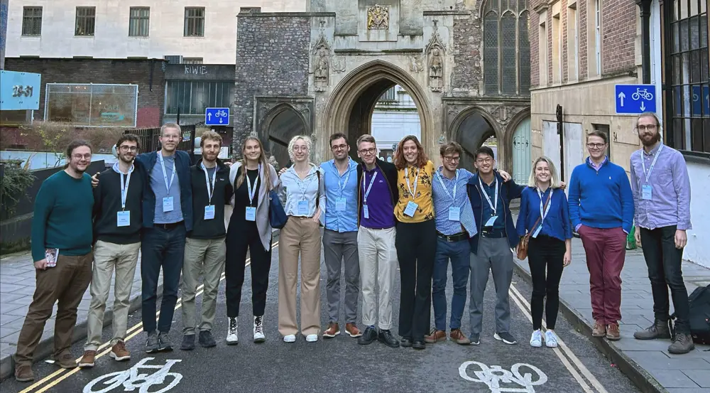 Dr Harrison and his research group standing together outside at the University of Oxford.