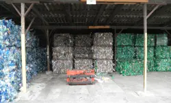 Cubed stacks of plastic waste under a shelter.