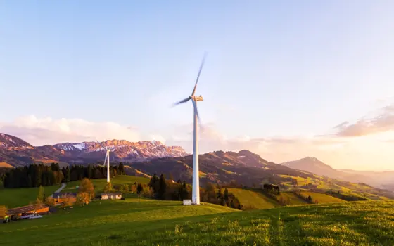 A wind turbine on a hillside in the mountains