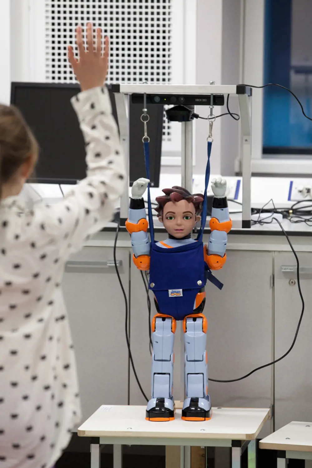 The American Zenorobot humanoid robot with its arms up, mimicking a human standing in front of it.