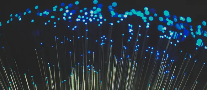 Fiber optic light cables with red hue on black background.