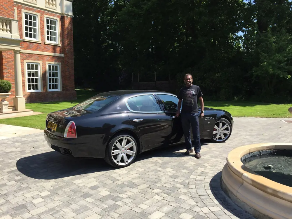 Ahilan standing next to a shiny car.