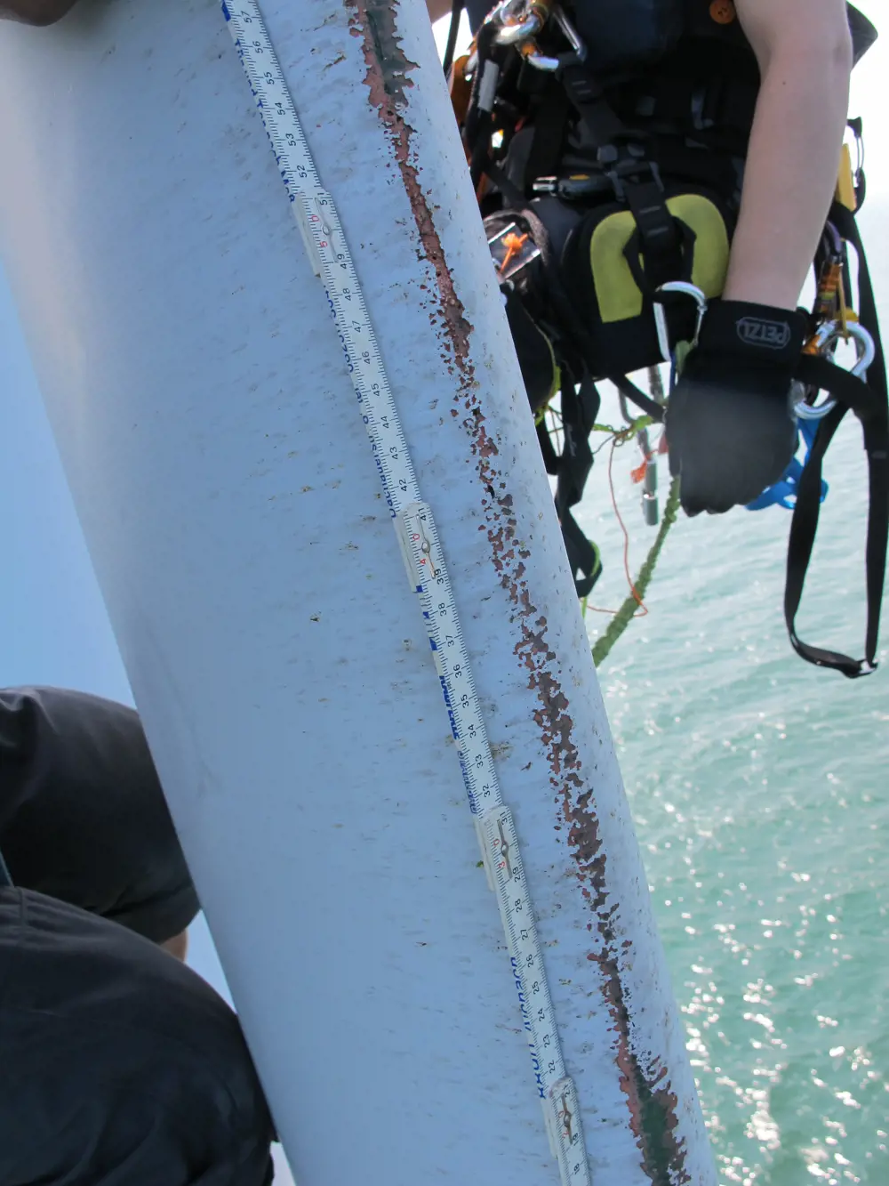 A close-up of the damage on a wind turbine blade out at sea.
