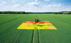 A tractor going over a digital map that has been projected onto a field.