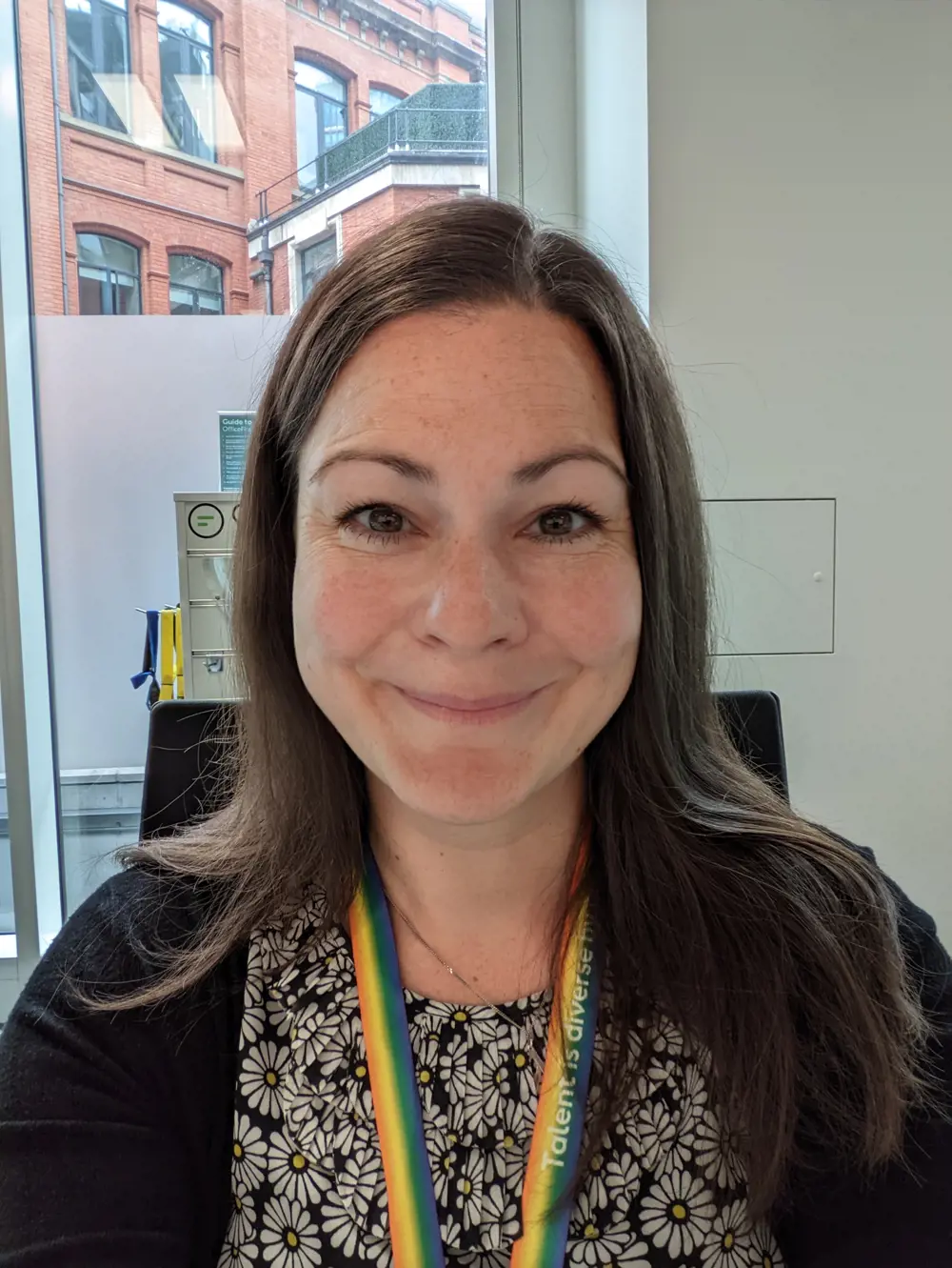 Woman with long brown hair looks at the camera