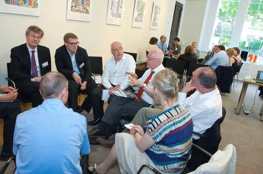 David Cleevely sitting with a group of policy fellows in a circle. 