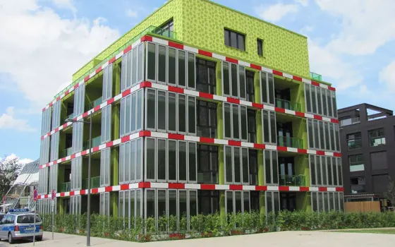 An apartment with green microalgae tanks built into the outside of the building.