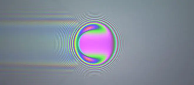 Coloured optical interference fringes around a ball.