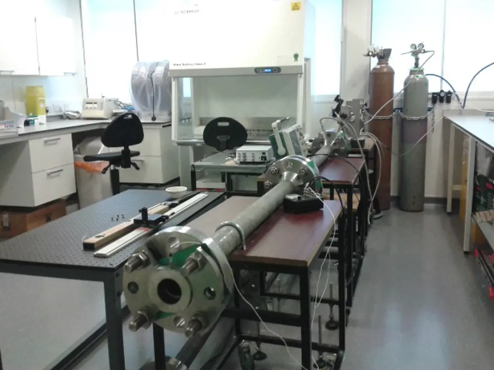 A metal tube resting on stands inside a lab. 