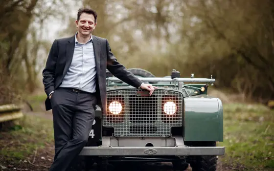 Nick Rogers smiling, standing in front of a Land Rover.