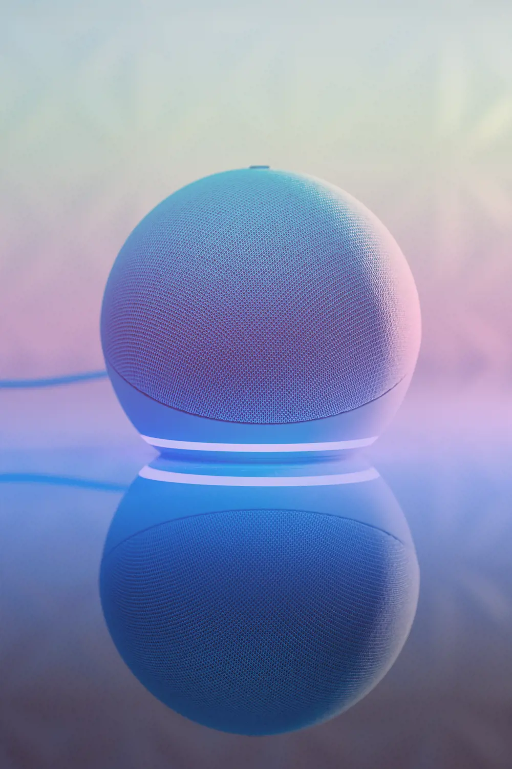A smart speaker sitting on a reflective surface.