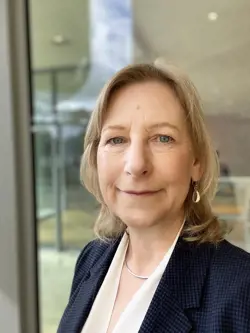 White woman with blonde hair looks at the camera