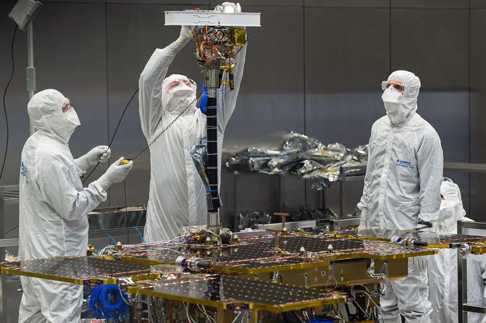 Three staff fit the PanCam to the ExoMars rover in Stevenage. 