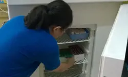 Someone putting medicines into a freezer.