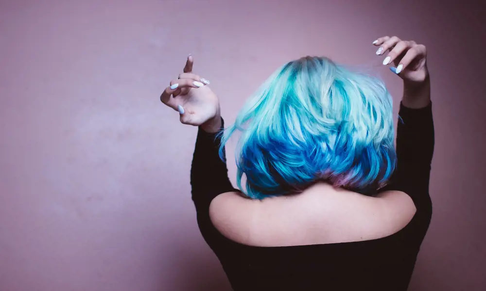 A person with blow-dried blue and pink hair