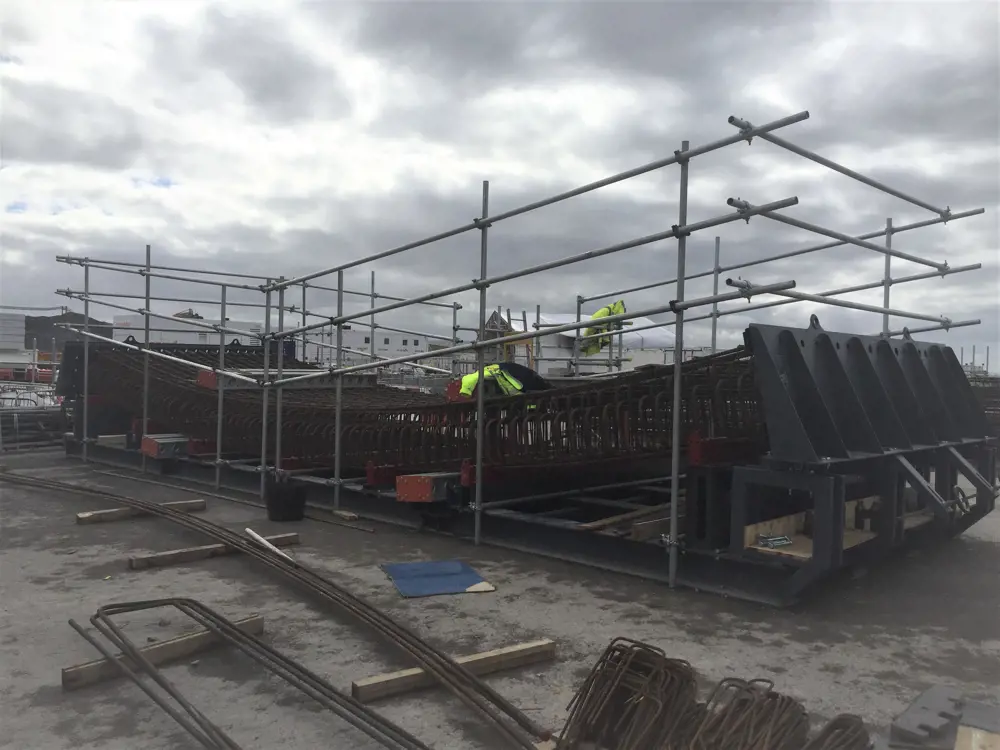 A construction site with a structure that is composed of metal poles that form frames.