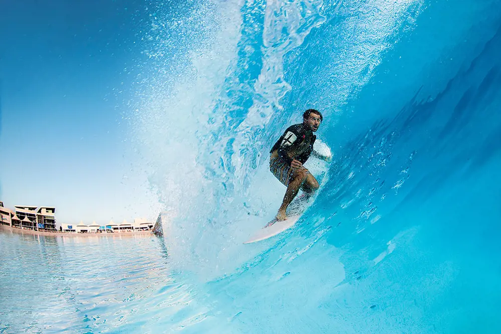 A male surfing inside of a wave.