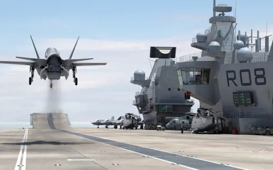 A 50 F-35B fighter jet taking off from a ship's deck.