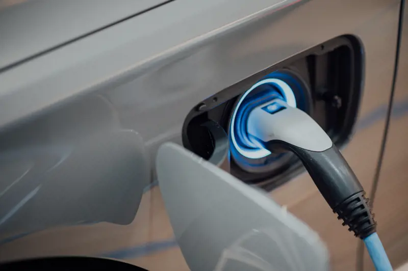 Side of an electric vehicle showing the charger plugged in