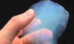 A hand holding a transparent aerogel material.