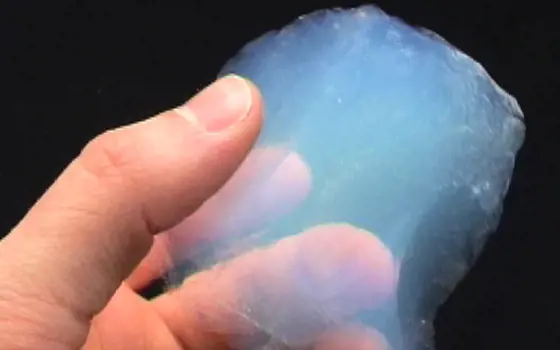 A hand holding a transparent aerogel material.
