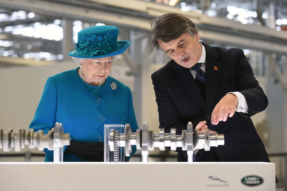 Dr Ralf Speth standing next to HRH The Queen, explaining engine parts in 2014. 