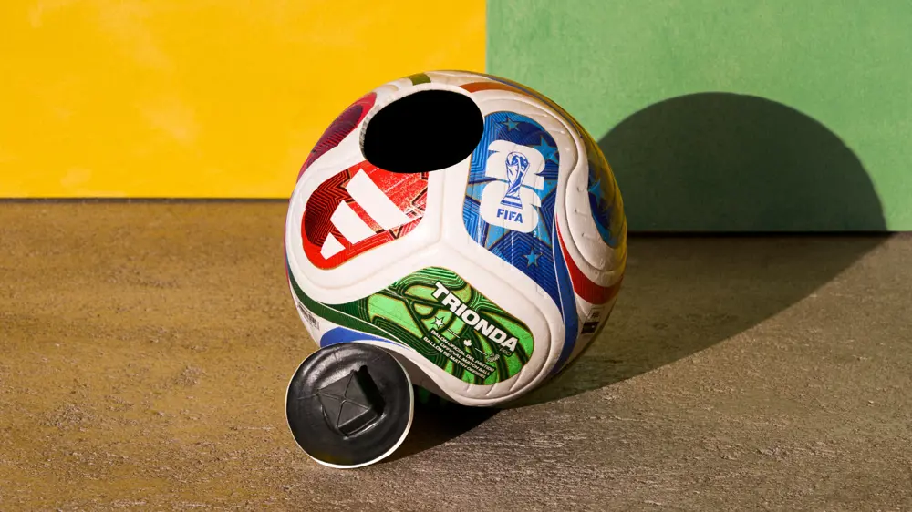 Adidas Trionda football with removable panel, showing internal electronic mechanism against a bright studio background.