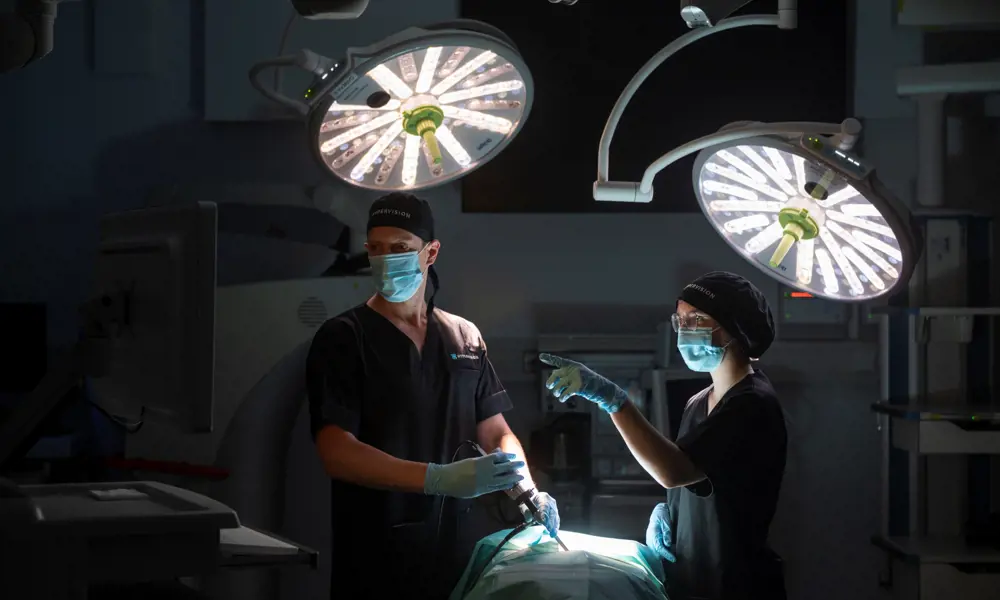 Two surgeons in discussion as they perform keyhole surgery in theatre