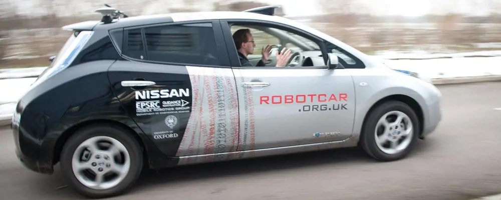 A person in the Nissan Robotcar, driving along a road without touching the wheel.