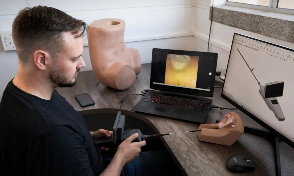 A biomedical engineer testing out a mobile hysteroscopy device in an office.