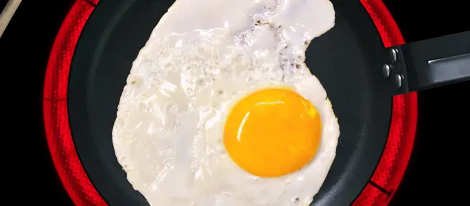 A fried egg in a pan on an induction hob.