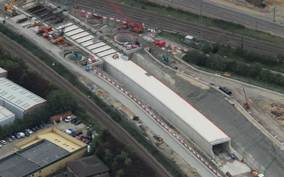 Aerial shot of multiple rail tracks with the construction of a tunnel between them.