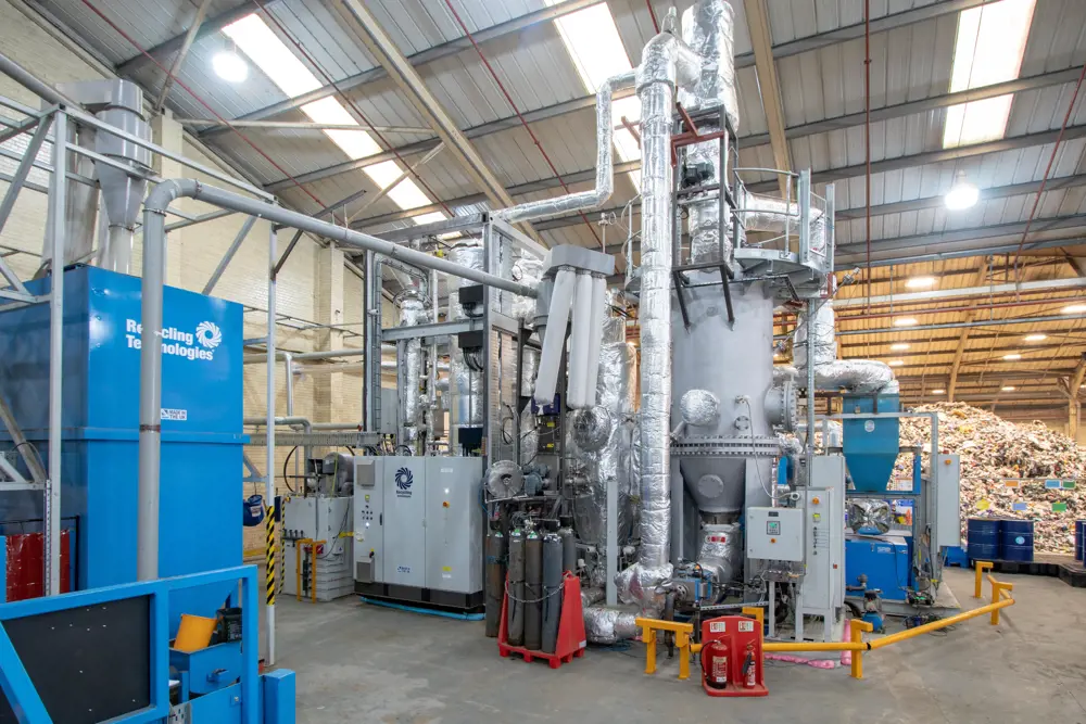 The RT7000 machine inside a factory with plastic waste in the background.