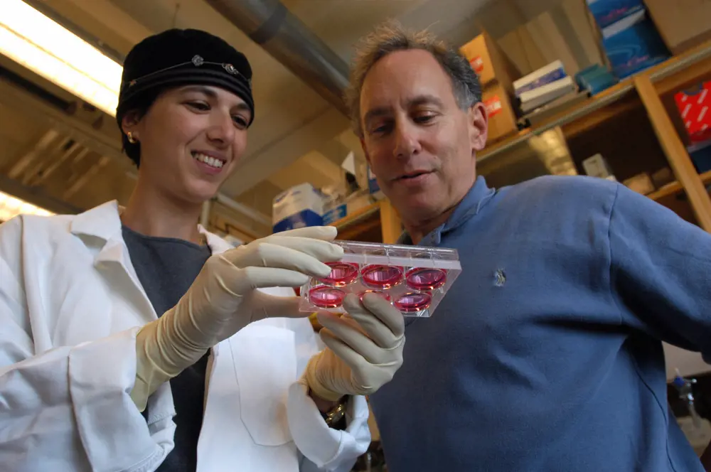Dr Shulamit Levenberg holding a plastic well, next to Dr Robert Langer.